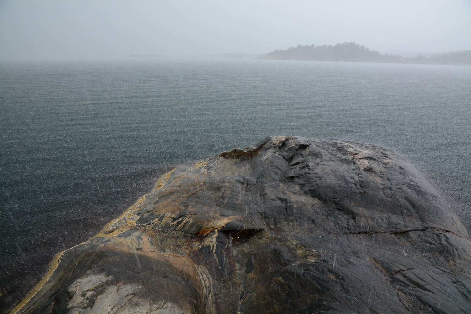 Regn i Lillesand. Saltholmen fyr skimtes i bakgrunnen.