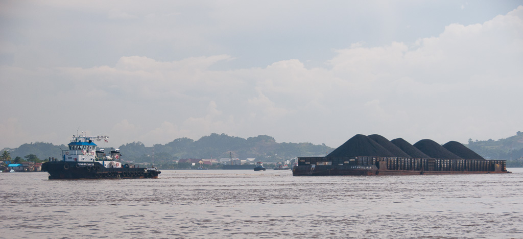 Every 10 minutes a coal barge passes down the Mahakam river in Samarinda.